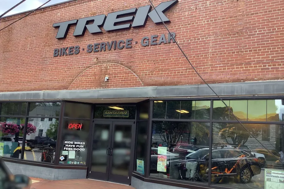 The red brick front of Atlanta Trek Newnan, with the Trek sign reading Bikes, Service, Gear above wide shop windows and an Open sign.